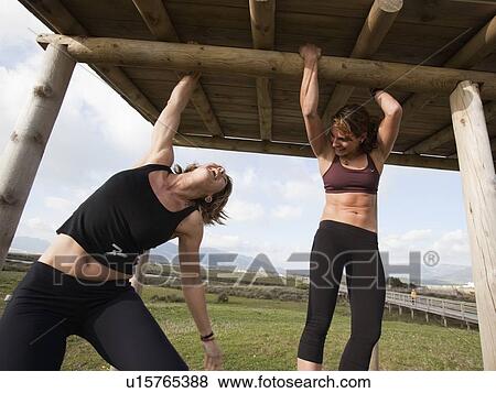 Two women hanging from wooden structure View Large Photo Image Stock Photo - Two women hanging from wooden structure . Fotosearch