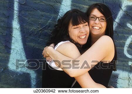 Stock Image - Two women hugging each other. Fotosearch