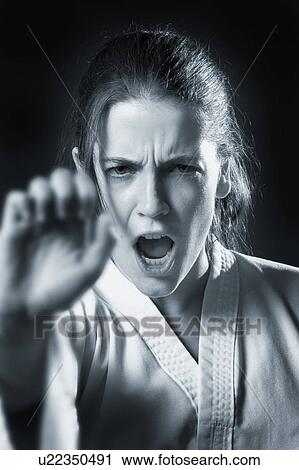 Stock Image - woman doing a karate punch in black and white. Fotosearch