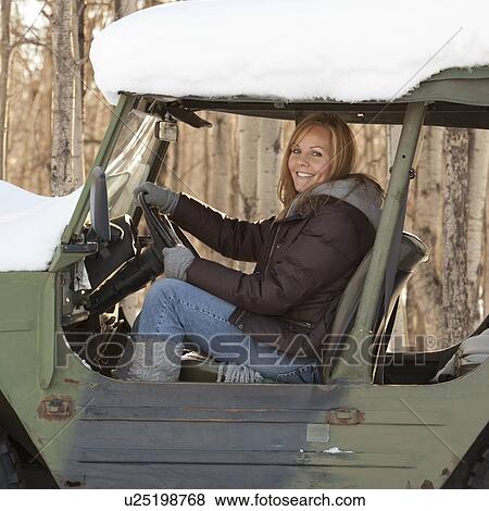 Stock Photo - Woman in a snow covered vehicle. Fotosearch