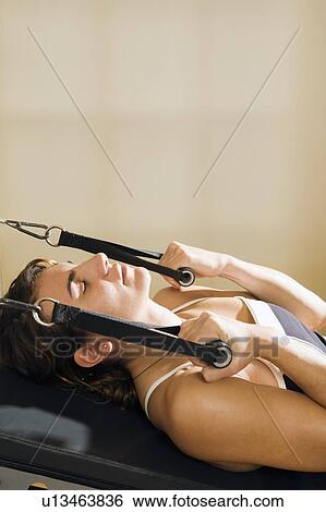 Stock Photograph - Woman on exercise machine. Fotosearch
