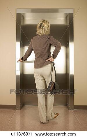 Stock Image - Woman waiting for an elevator. Fotosearch