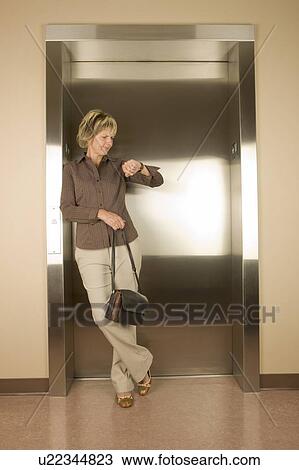 Stock Image - Woman waiting for an elevator. Fotosearch