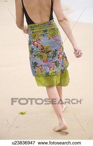 Woman walking along the beach View Large Photo Image Stock Photo - Woman walking along the beach. Fotosearch