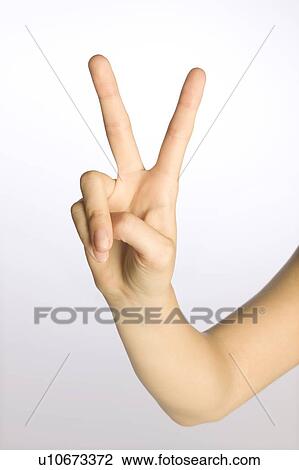 Stock Image - Woman's hand making a peace sign. Fotosearch