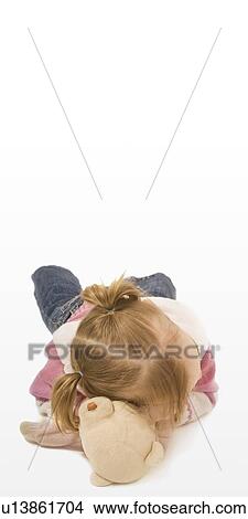 Young girl resting her head on top on a teddy bear View Large Photo Image Picture - Young girl resting her head on top on a teddy bear. Fotosearch