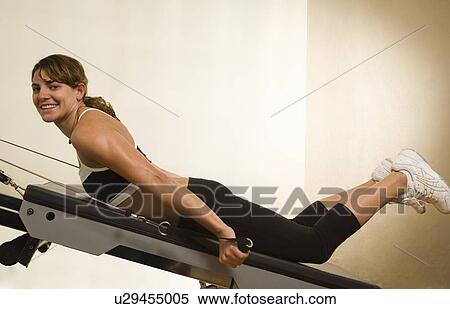 Stock Photography - Young woman exercising in the gym. Fotosearch