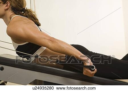 Stock Image - Young woman exercising. Fotosearch