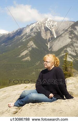 Young woman sitting in the mountains, Jasper, Canada View Large Photo Image Stock Photo - Young woman sitting in the mountains, Jasper, Canada. Fotosearch