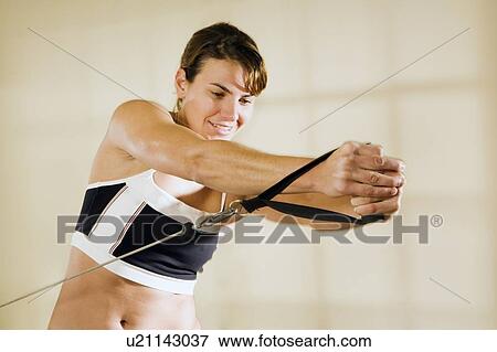 Stock Photo - Young woman training in gym . Fotosearch