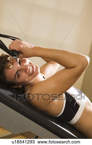 Stock Image - Young woman working out. Fotosearch