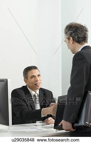 Stock Photo - A business colleagues shaking hands. Fotosearch