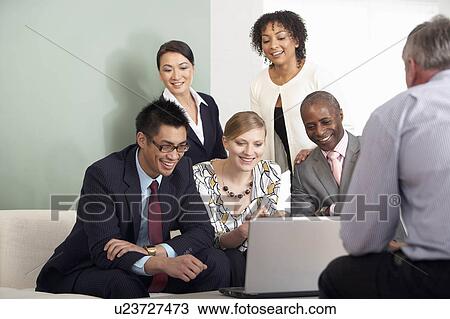 A business group around a laptop View Large Photo Image Stock Image - A business group around a laptop. Fotosearch
