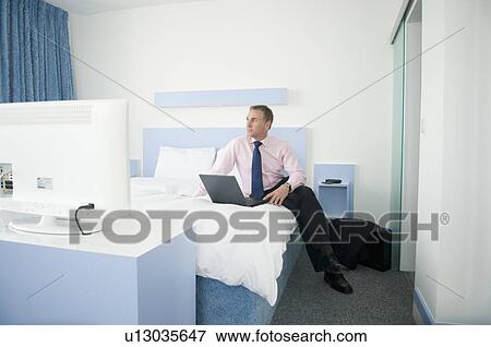 Stock Photo - A businessman in his hotel room. Fotosearch
