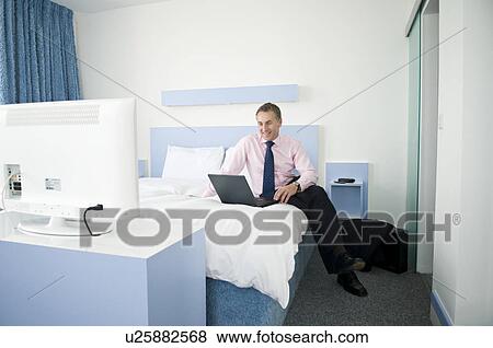 Stock Photo - A businessman in his hotel room. Fotosearch