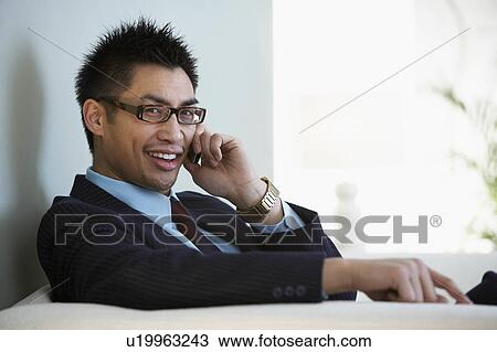 Stock Image - A businessman on his mobile phone. Fotosearch