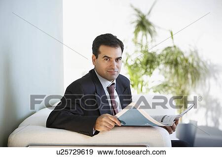 Stock Photo - A businessman reading the paper. Fotosearch