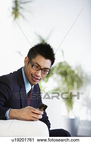 Stock Image - A businessman texting. Fotosearch