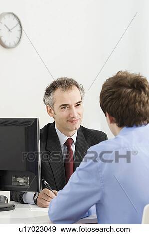 Stock Photo - A latin business manager with a customer. Fotosearch