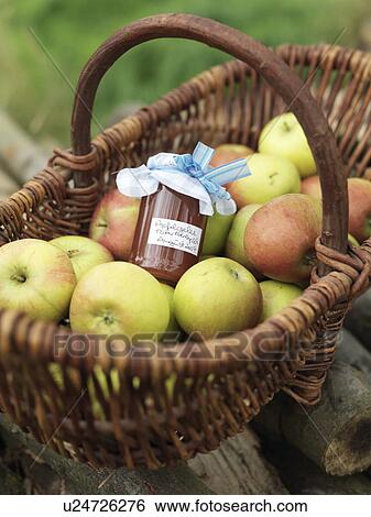 Stock Photograph - Apples in basket with jar of apples. Fotosearch