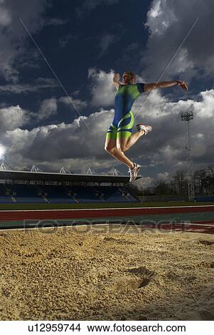 Picture - athlete mid flight jumping. Fotosearch