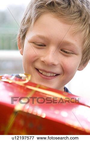 Boy, 10 holding present View Large Photo Image Stock Photo - Boy, 10 holding present. Fotosearch