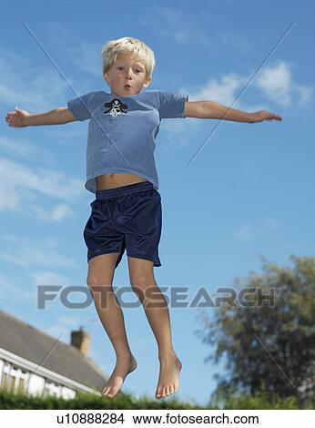 Boy, 7 playing on trampoline View Large Photo Image Picture - Boy, 7 playing on trampoline. Fotosearch