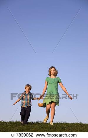 boy and girl running, holding basket View Large Photo Image Stock Image - boy and girl running, holding basket. Fotosearch