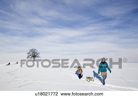 Boy and Girl with a sledge in snow View Large Photo Image Stock Image - Boy and Girl with a sledge in snow. Fotosearch