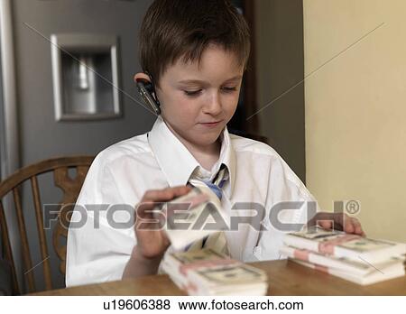 Boy counting money at table View Large Photo Image Stock Photo - Boy counting money at table. Fotosearch