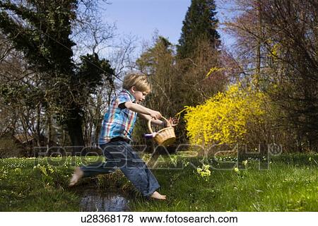 boy jumping over creek holding basket View Large Photo Image Stock Photo - boy jumping over creek holding basket. Fotosearch