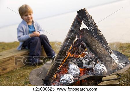 boy looking at potatoes barbecue fire View Large Photo Image Stock Photography - boy looking at potatoes barbecue fire. Fotosearch