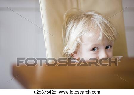 Stock Photography - boy looking over table edge. Fotosearch