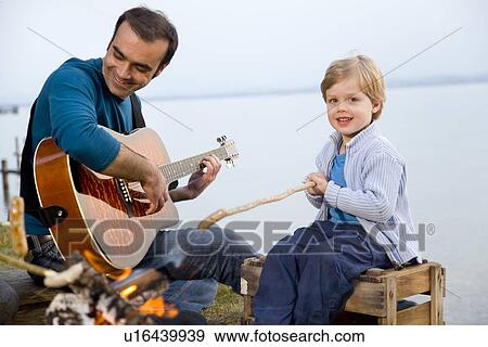 boy, man with guitar roasting sausages View Large Photo Image Stock Photo - boy, man with guitar roasting sausages. Fotosearch