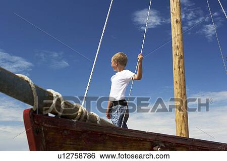 Boy on sailing boat View Large Photo Image Stock Photograph - Boy on sailing boat. Fotosearch