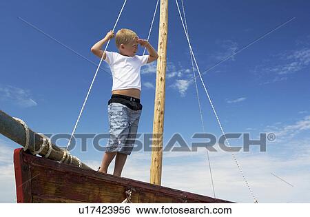 Boy on sailing boat View Large Photo Image Stock Photograph - Boy on sailing boat. Fotosearch