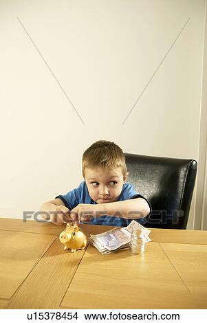 boy putting money in piggy bank View Large Photo Image Picture - boy putting money in piggy bank. Fotosearch