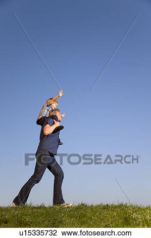 boy sitting on father's shoulders View Large Photo Image Stock Image - boy sitting on father's shoulders. Fotosearch