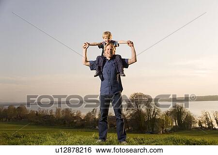 boy sitting on father's shoulders View Large Photo Image Stock Photograph - boy sitting on father's shoulders. Fotosearch
