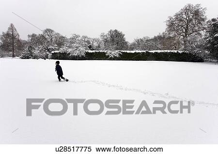 Boy walking through snow field View Large Photo Image Stock Photography - Boy walking through snow field. Fotosearch