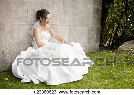 Bride sitting at a wall. View Large Photo Image Stock Image - Bride sitting at a wall.. Fotosearch