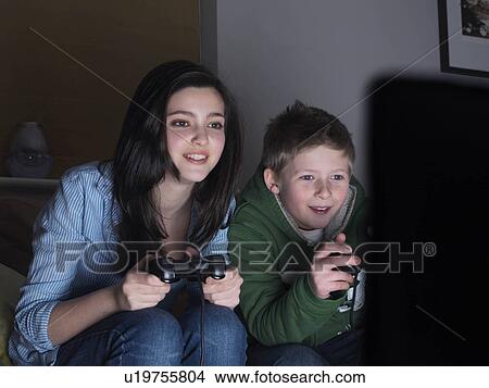 Brother and sister playing TV game View Large Photo Image Picture - Brother and sister playing TV game. Fotosearch