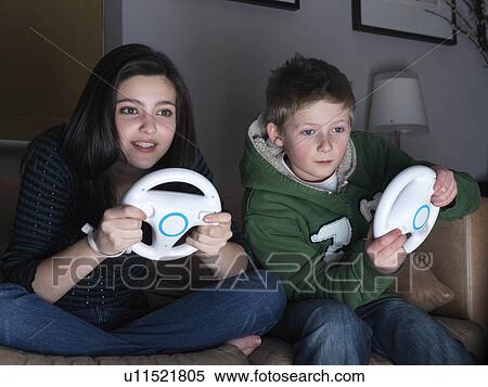 Brother ans sister playing driving game View Large Photo Image Stock Photography - Brother ans sister playing driving game. Fotosearch