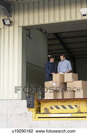 Businessman and worker in warehouse View Large Photo Image Stock Image - Businessman and worker in warehouse. Fotosearch