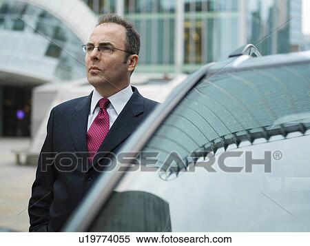 Businessman, chauffeur stood by car View Large Photo Image Stock Photography - Businessman, chauffeur stood by car. Fotosearch