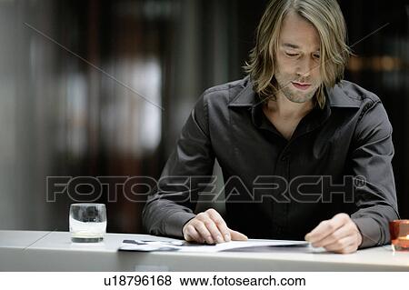 Businessman reading in bar View Large Photo Image Stock Photo - Businessman reading in bar. Fotosearch
