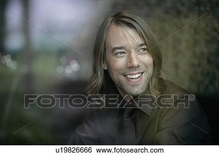 Stock Photograph - Businessman smiling through window. Fotosearch