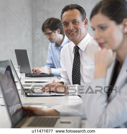 Businessman using laptop, smiling View Large Photo Image Stock Photo - Businessman using laptop, smiling. Fotosearch