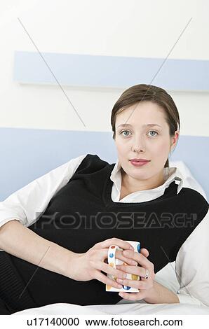 Businesswoman relaxing in her bedroom View Large Photo Image Stock Image - Businesswoman relaxing in her bedroom. Fotosearch