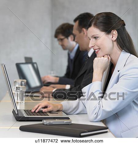 Businesswoman using laptop, smiling View Large Photo Image Stock Image - Businesswoman using laptop, smiling. Fotosearch
